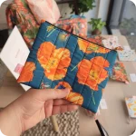 Astuccio realizzato in tessuto stampato con papaveri, lucciole, falene e grilli su sfondo blu
