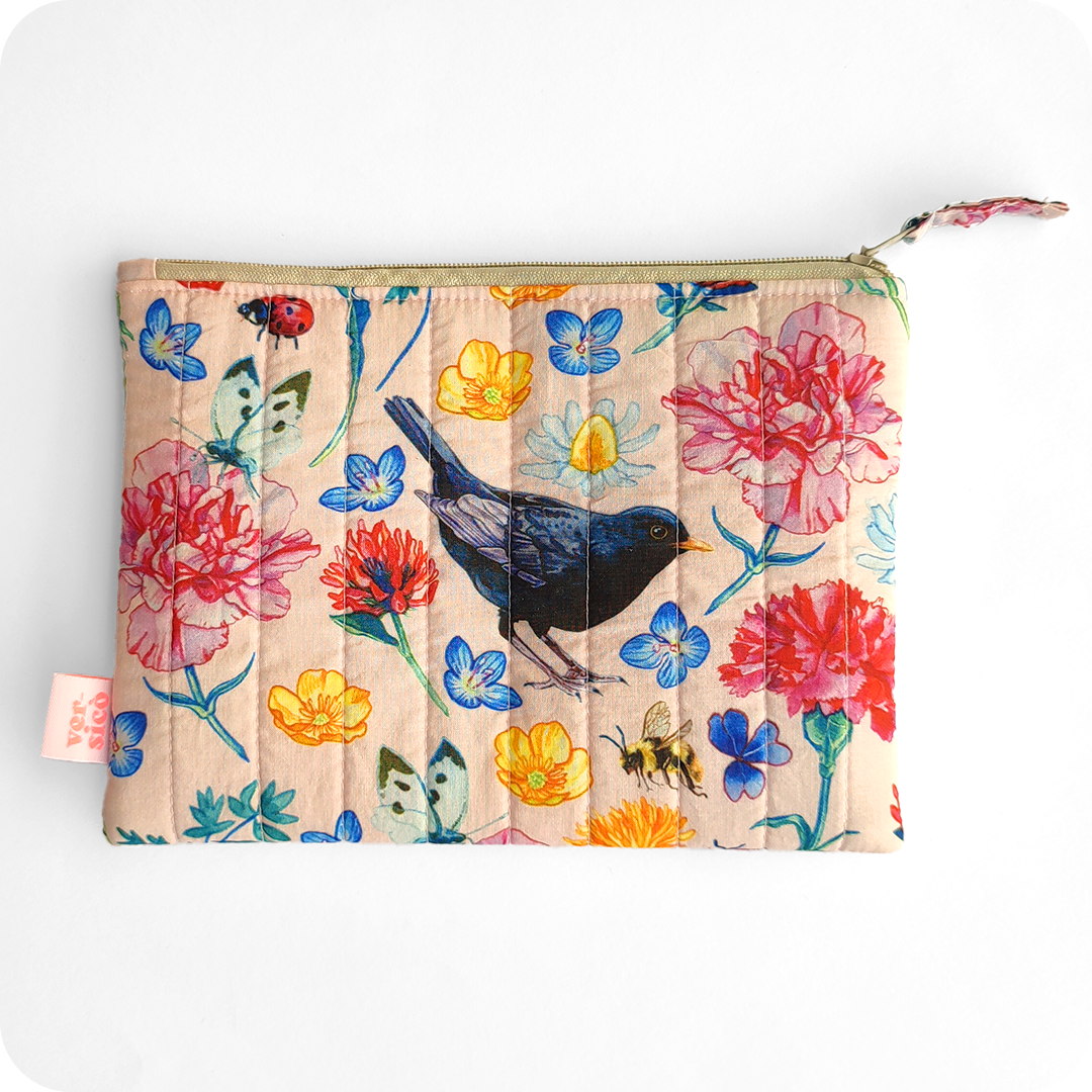 Astuccio realizzato con tessuto stampato con un merlo al centro attorniato da fiori, fragole, foglie, api, coccinelle e farfalle su sfondo rosa