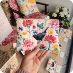 Astuccio realizzato con tessuto stampato con un merlo al centro attorniato da fiori, foglie e insetti su sfondo rosa