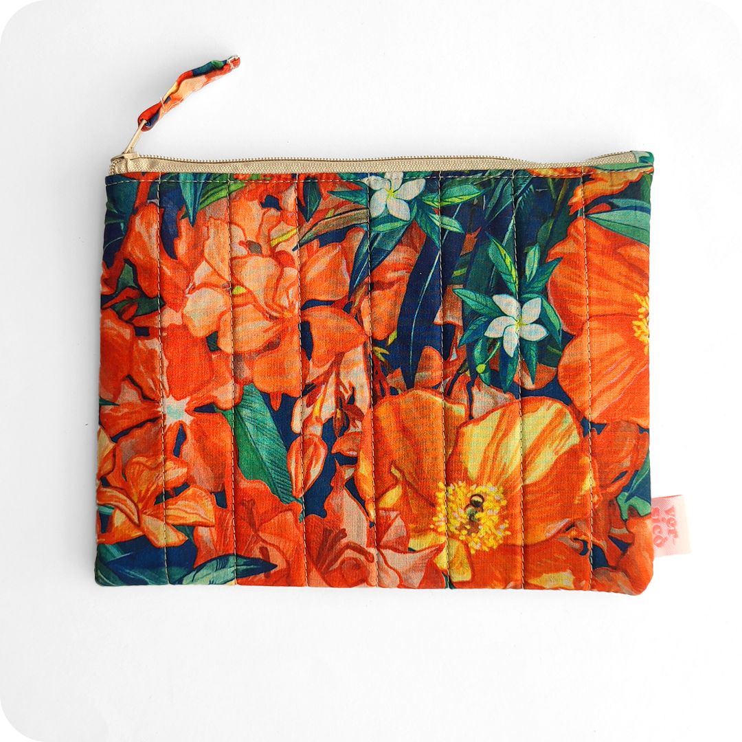 Astuccio realizzato con tessuto stampato con fiori sui toni dell'arancione e foglie bluastre