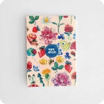 Biglietto d'auguri con il logo di Versicò al centro attorniato da fiori, foglie, coccinelle, api, farfalle e chiocciola su fondo rosa