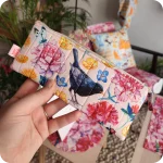 Astuccio porta matite realizzato co un tessuto con merli, insetti e fiori su fondo rosato