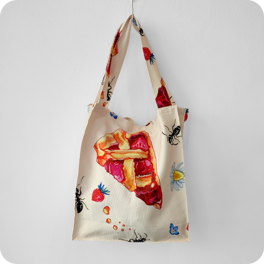 Borsa in tessuto stampato con una fantasia con fette di crostata, formiche, fiori e fragole su fondo chiaro