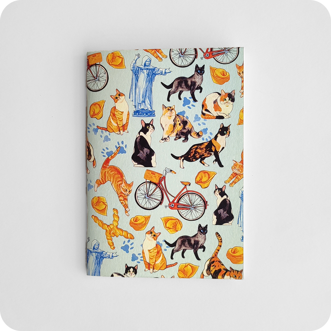 Fronte di un taccuino decorato con disegni di gatti, biciclette, coppie di pane, la statua del Savonarola e impronte su un fondo azzurro