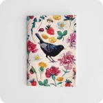 Fronte di un taccuino decorato con un merlo al centro attorniato da fiori, fragole, coccinelle, api su un fondo rosa