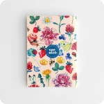 Retro di un taccuino con il logo di Versicò al centro attorniato da fiori, fragole, coccinelle, api su un fondo rosa