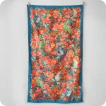 Telo mare appeso realizzato con un decoro centrato con pappagalli e fiori e una cornice blu