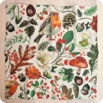 Tovagliolo quadrato aperto in lino écru stampato con una fantasia di pettirossi, pigne, rametti, fiori, funghi, ghiande, bacche, foglie