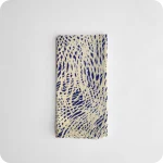 Tovagliolo piegato in tessuto stampato con una fantasia di tratteggi bianchi su fondo blu